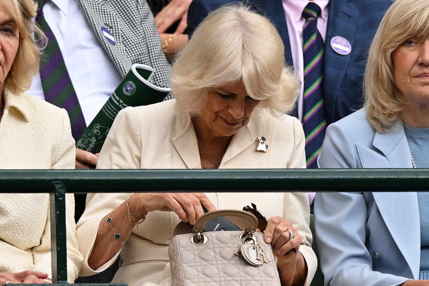 Queen Camilla uses a during a break in the play of between US player Taylor Fritz and Italy's Lorenzo Musetti, in their men's singles quarter-finals tennis match on the tenth day of the 2024