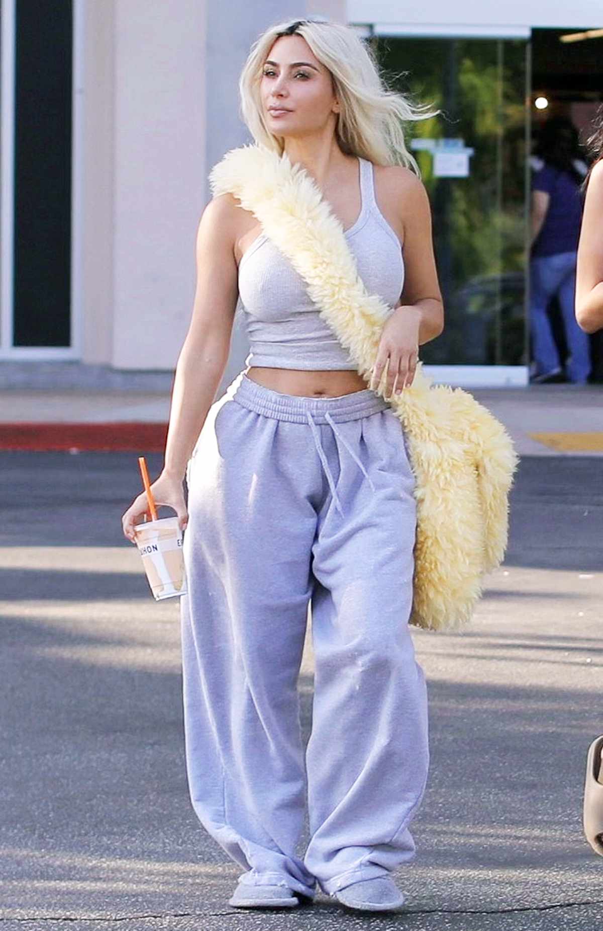 Kim Kardashian shops at Erehwon and sips on a smoothie with s friend while carrying a fluffy bag in Calabasas.