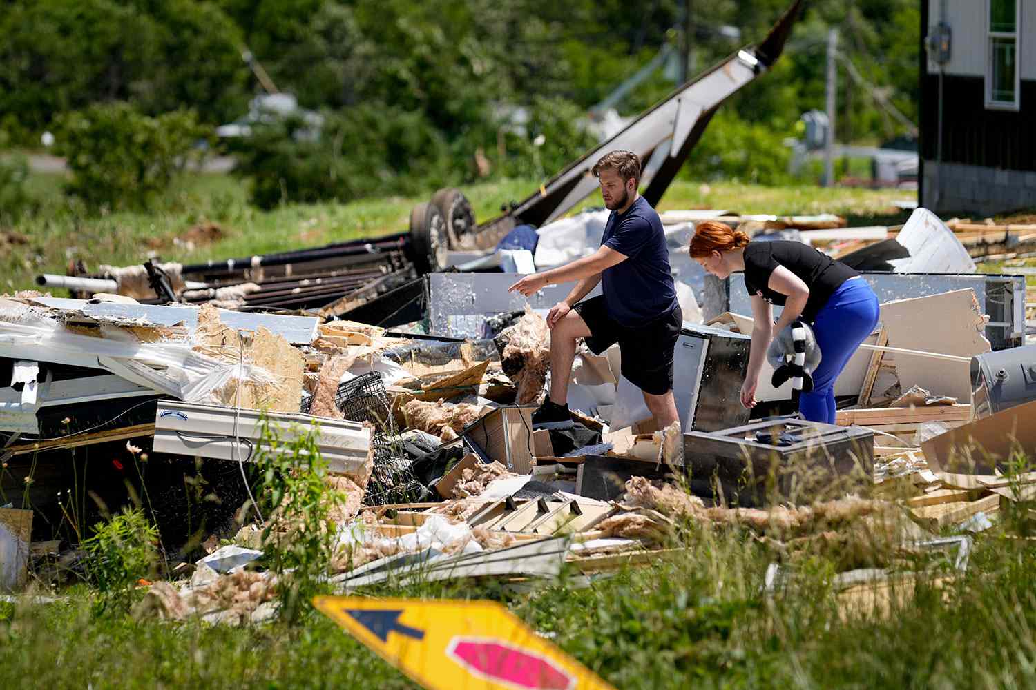 Devin Johnson, and his fiancee Haley Loukota, right, look for their belongings in their demolished home along Barnsley Loop, Tuesday, May 28, 2024, in Madisonville, Ky. A series of powerful storms hit the central and southern U.S. over the Memorial Day holiday weekend. 