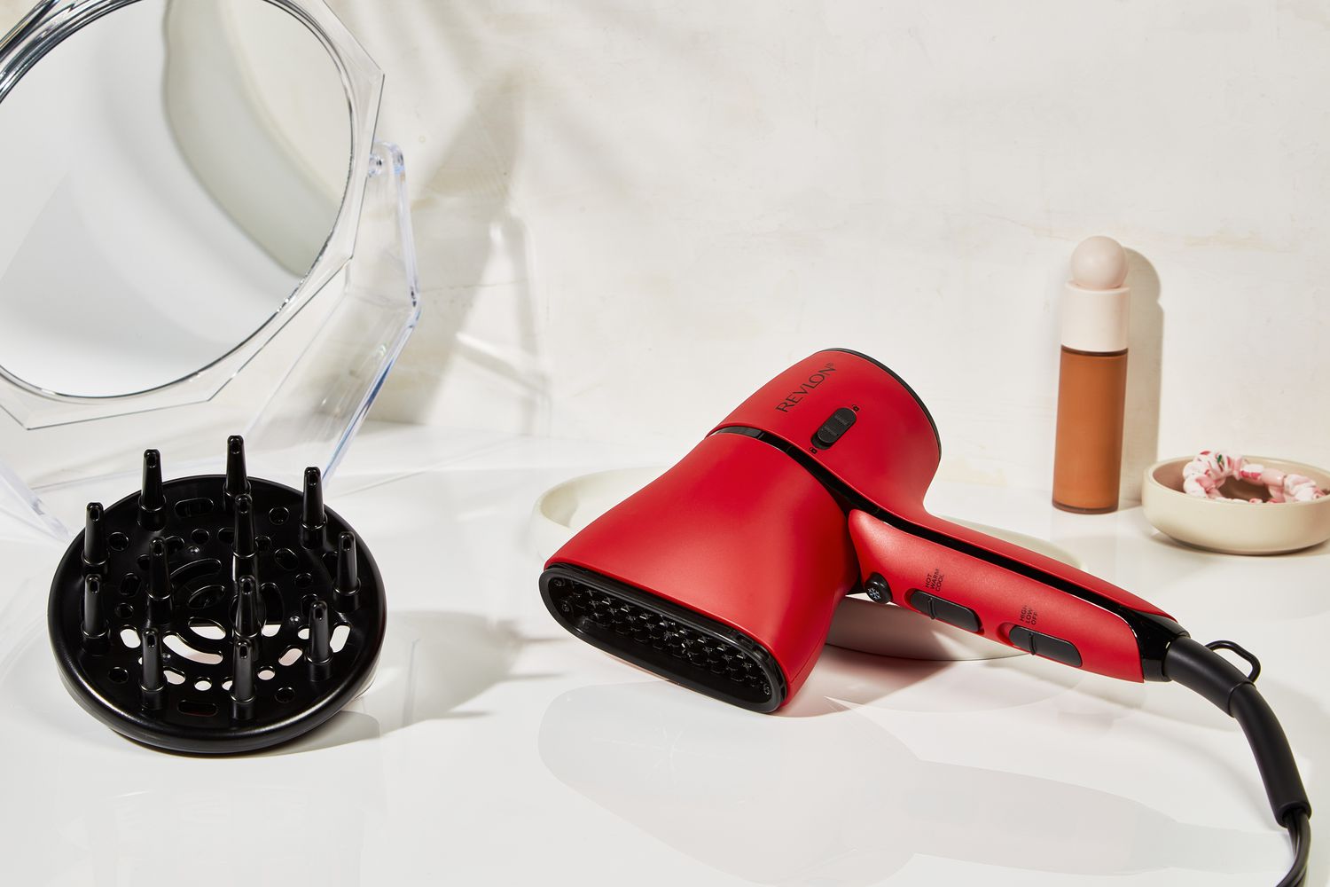 The Revlon Airflow Control Dryer and accessories on a white bathroom counter.