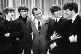 American television host Ed Sullivan (center) smiles as he stands, with the members of British rock group the Beatles, on the set of his television variety series, 'The Ed Sullivan Show' at CBS's Studio 50, New York, New York, February 9, 1964. 