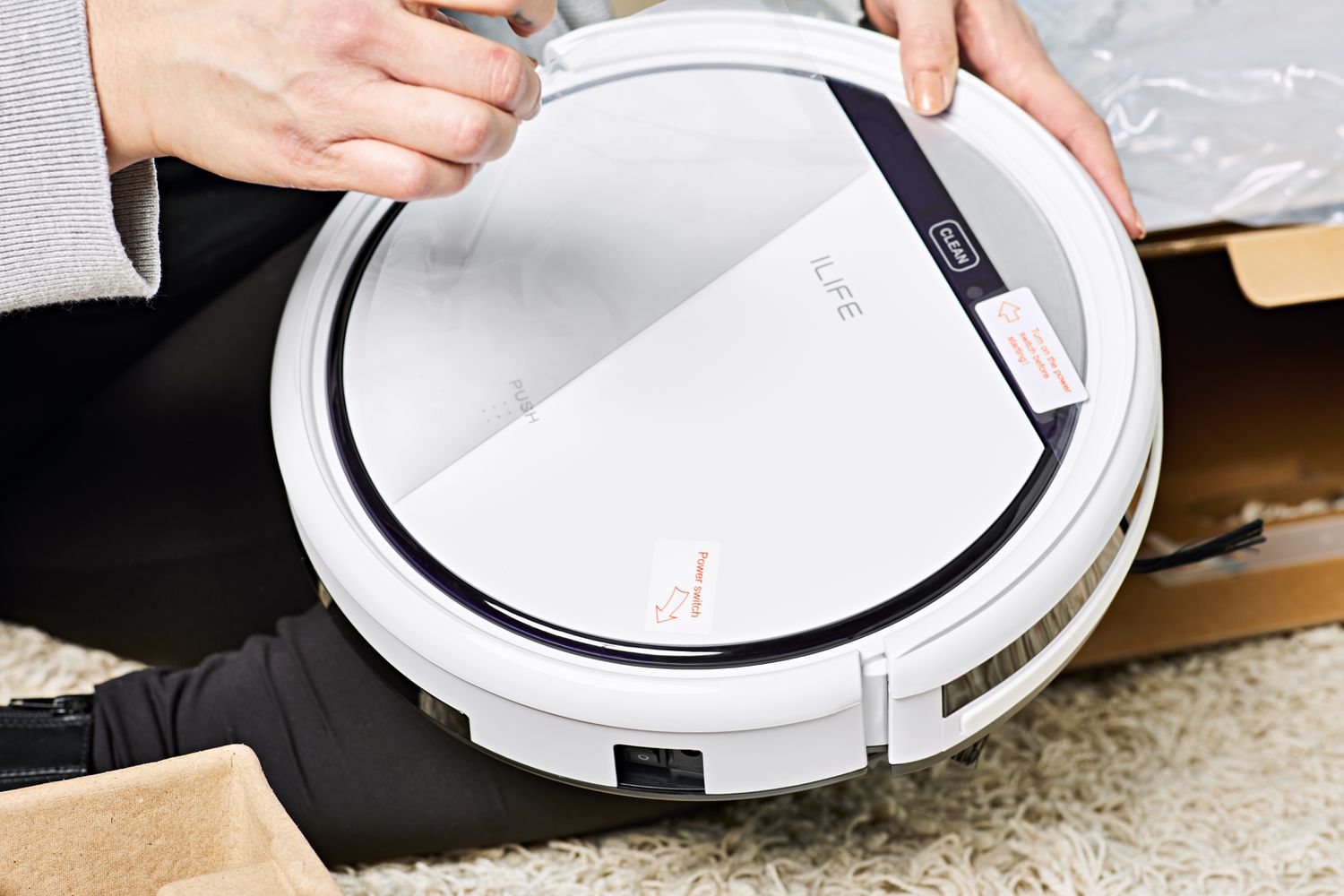 Person holding ILIFE V3s Pro Robot Vacuum Cleaner next to box