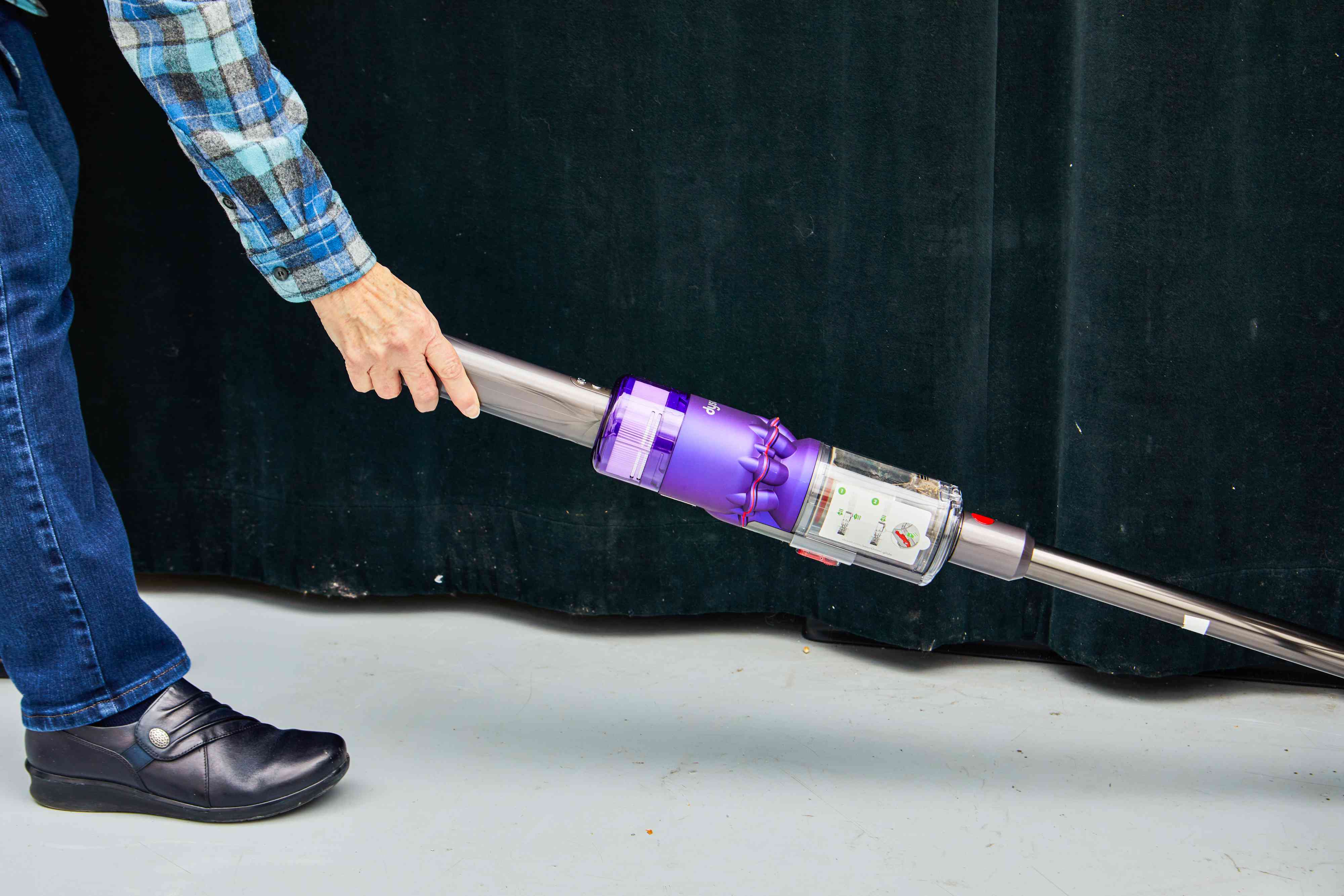 Person holding up Dyson Omni-Glide+ Cordless Vacuum to clean the floor