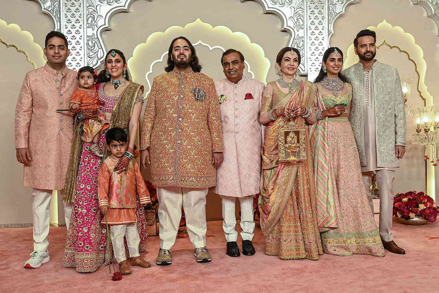 Billionaire tycoon and Chairman of Reliance Industries Mukesh Ambani (C) with his wife Nita Ambani (3R), daughter Isha Ambani (2R), sons Akash Ambani (L) and Anant Ambani (C, left), daughter-in-law Shloka Mehta (2L), and son-in-law Anand Piramal pose for photos as they arrive to attend the wedding ceremony of Anant and Radhika Merchant in Mumba