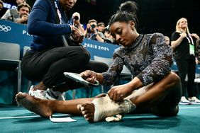 US' Simone Biles puts a strap on her left ankle during the artistic gymnastics women's qualification during the Paris 2024 Olympic Games at the