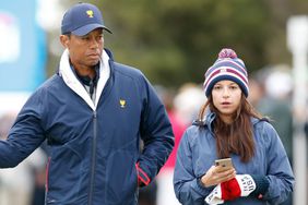 MELBOURNE, AUSTRALIA - DECEMBER 14: Playing Captain Tiger Woods of the United States team and girlfriend Erica Herman look on during Saturday four-ball matches on day three of the 2019 Presidents Cup at Royal Melbourne Golf Course on December 14, 2019 in Melbourne, Australia. (Photo by Darrian Traynor/Getty Images)