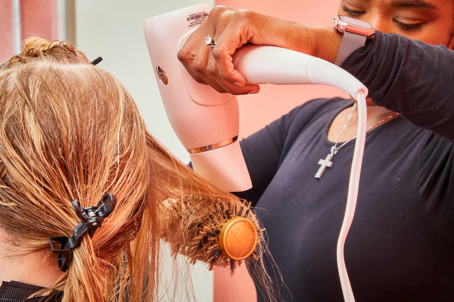 A person drying another person's hair using the T3 Afar Travel Size Hair Dryer and a round brush.