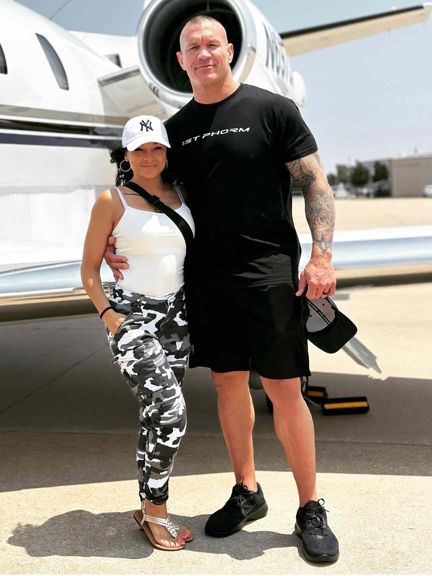 Randy Orton and Kimberly Marie Kessler posing next to a plane