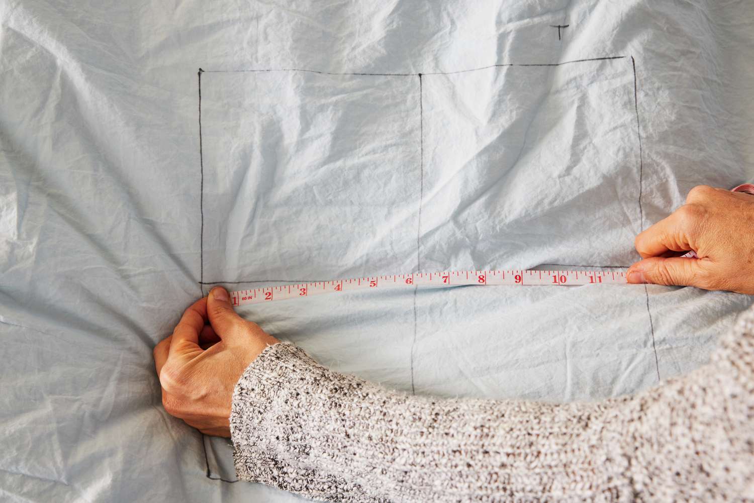 A person measuring the Riley Percale Duvet Cover