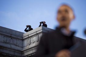 Secret Service snipers watch on a rooftop as President Barack Obama speaks