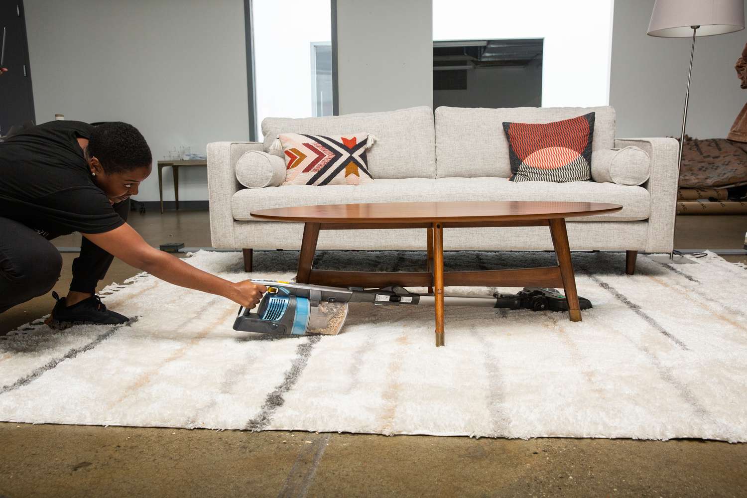 Person using Shark Vertex IZ462H Ultra Lightweight Cordless Stick Vacuum under a wood table on carpet