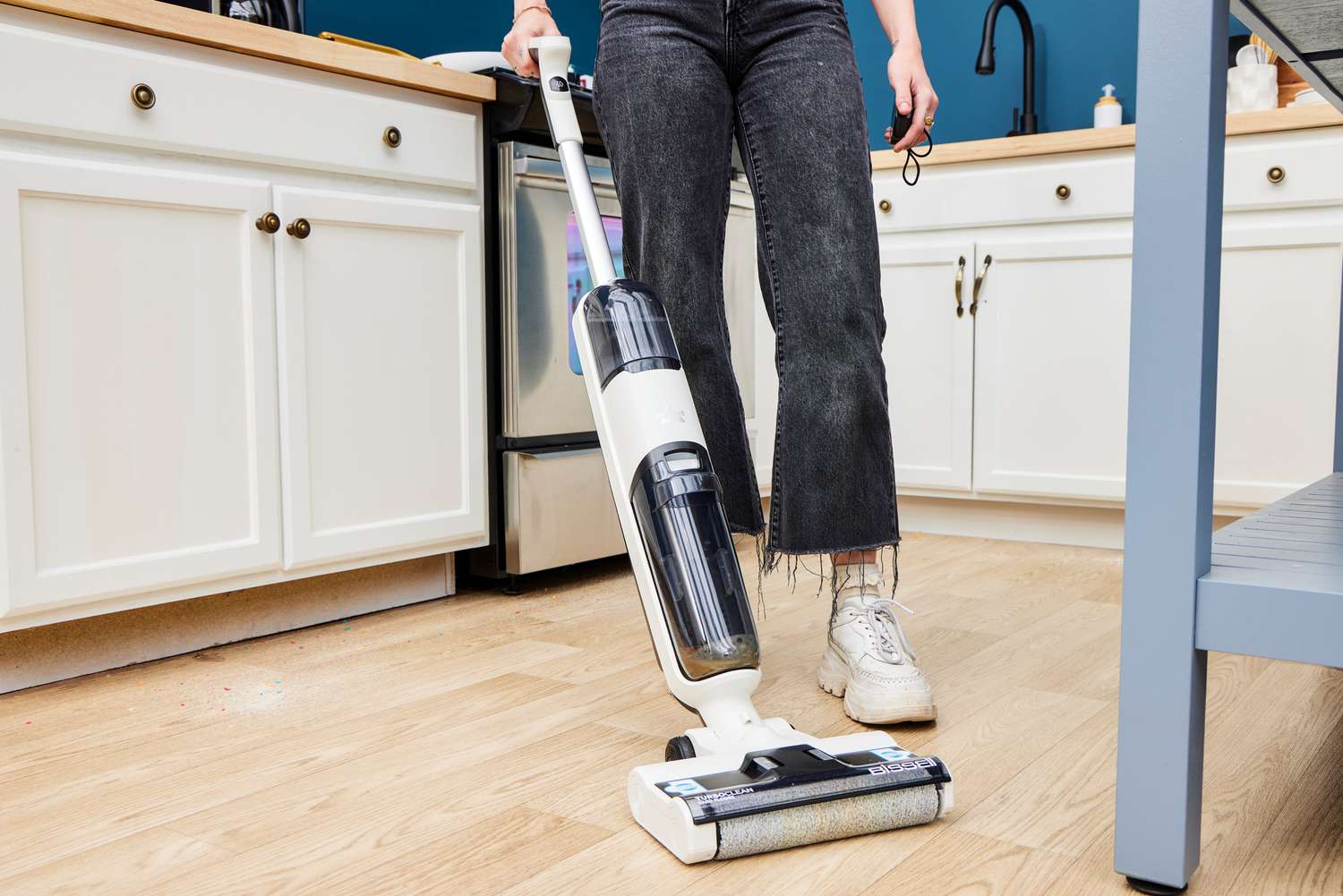 A person uses the Bissell TurboClean Cordless Hard Floor Cleaner on a hardwood floor