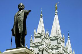  A statue of Brigham Young, second president of the Church of Jesus Christ of Latter Day Saints stands in the center of Salt Lake City with the Mormon Temple 