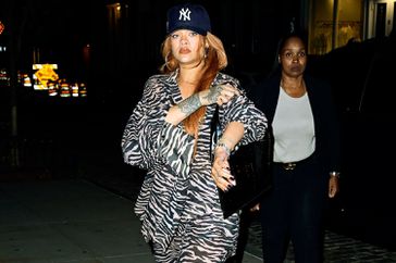 Rihanna effortlessly commands attention in a zebra two-piece outfit complemented by a chic blue NY hat and stylish silver flats as she takes a leisurely stroll with boyfriend A$AP Rocky through Soho, New York City.