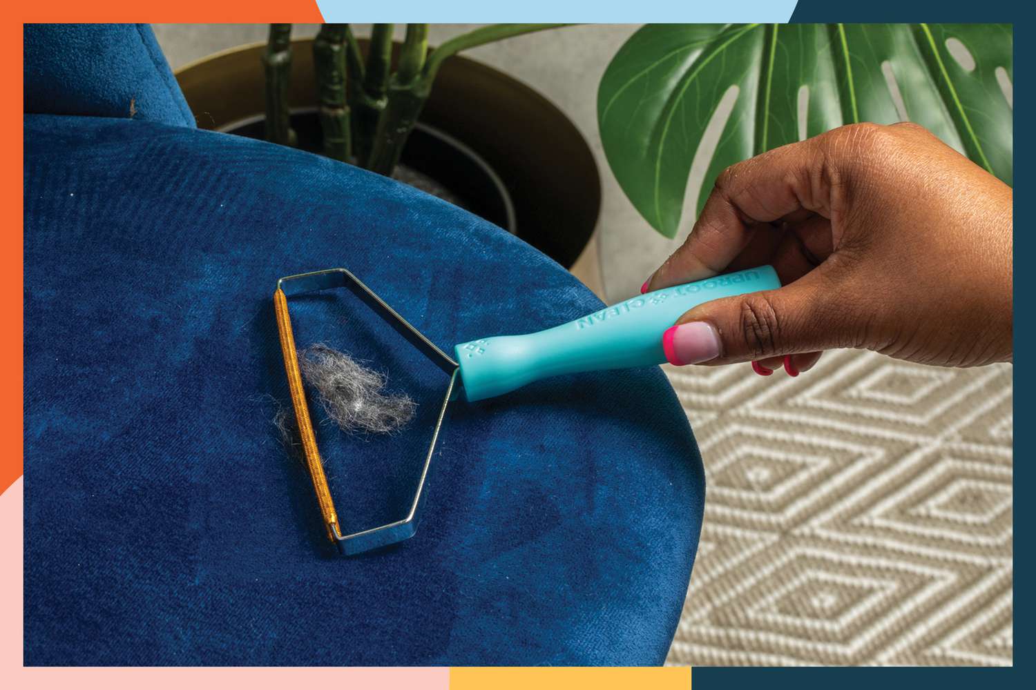 Hand cleaning fur from a plush chair with the Uproot Cleaner Pro Reusable Pet Hair Remover