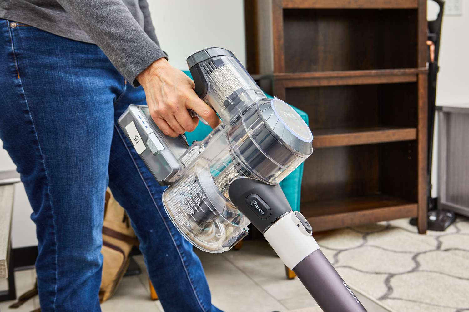 Hand holding Tineco Pure One S11 Smart Stick/Handheld Vacuum as it vacuums carpet