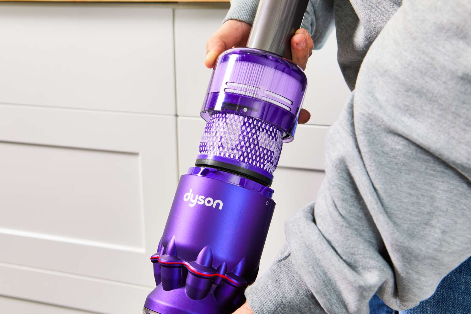 Closeup of a hand holding onto the top of the Dyson Omni-Glide+ Cordless Vacuum