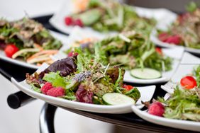 tray of plated fresh salad for wedding guests