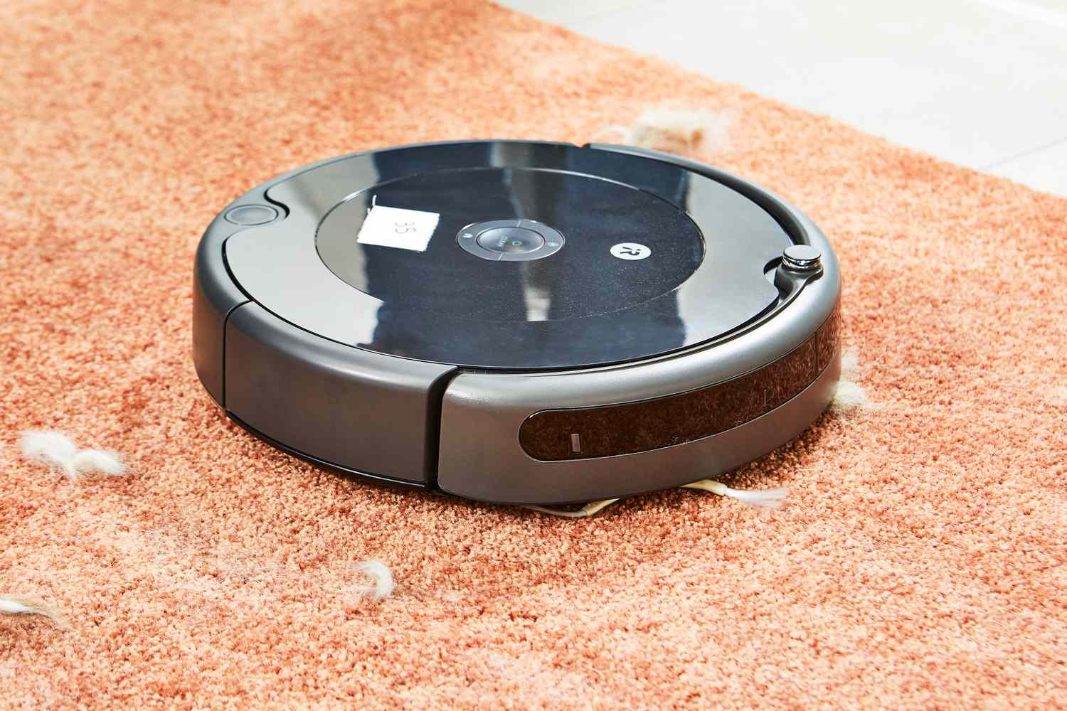 iRobot Roomba 694 Robot Vacuum cleaning fuzz from orange carpet
