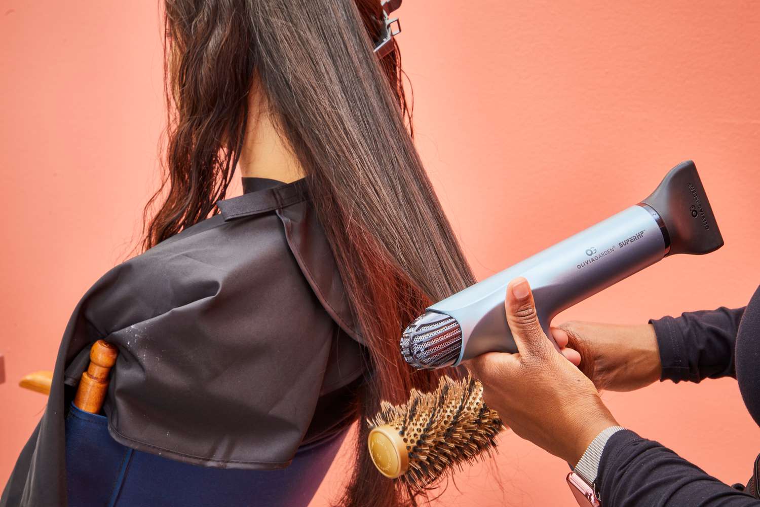 A person using the Olivia Garden High Performance Professional Hair Dryer to dry another person's hair.