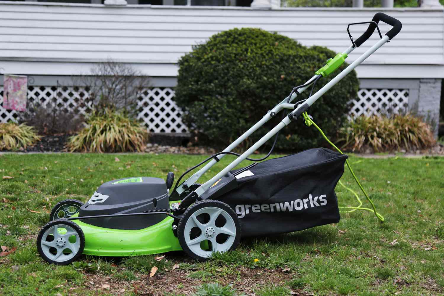 Greenworks 25022 12-Amp 20-Inch 3-in-1 Corded Lawn Mower plugged in while displayed on the grass