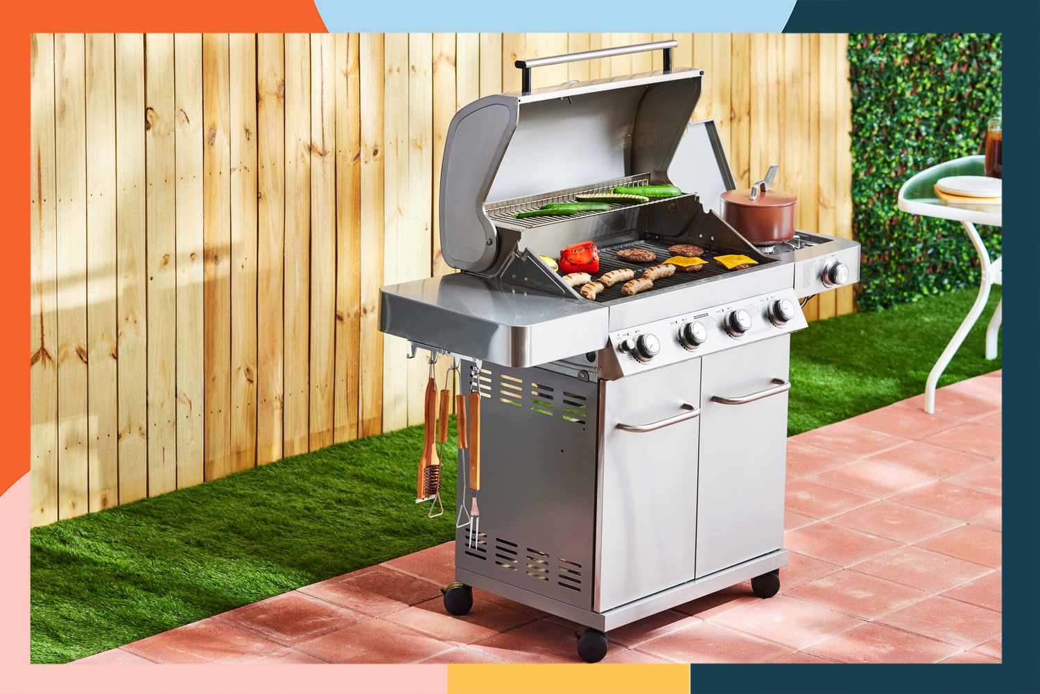 The Monument Grills 4-Burner Propane Gas Grill on a patio in a fenced yard