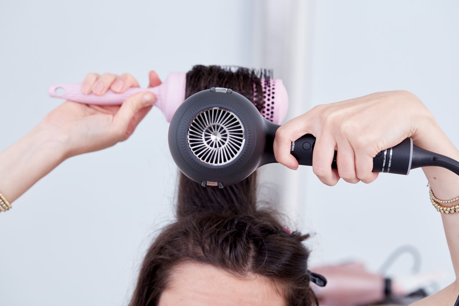 Person using the Hot Tools Pro Artist Black Gold Ionic Hair Dryer with a brush