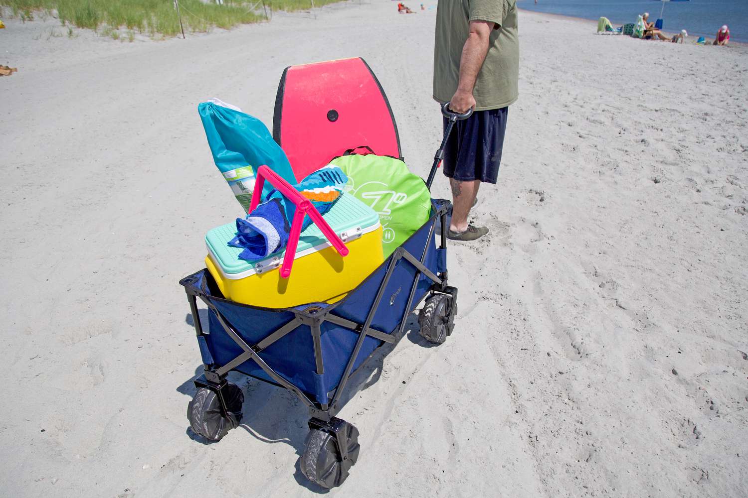 Portal Collapsible filled with beach accessories being pulled on sand