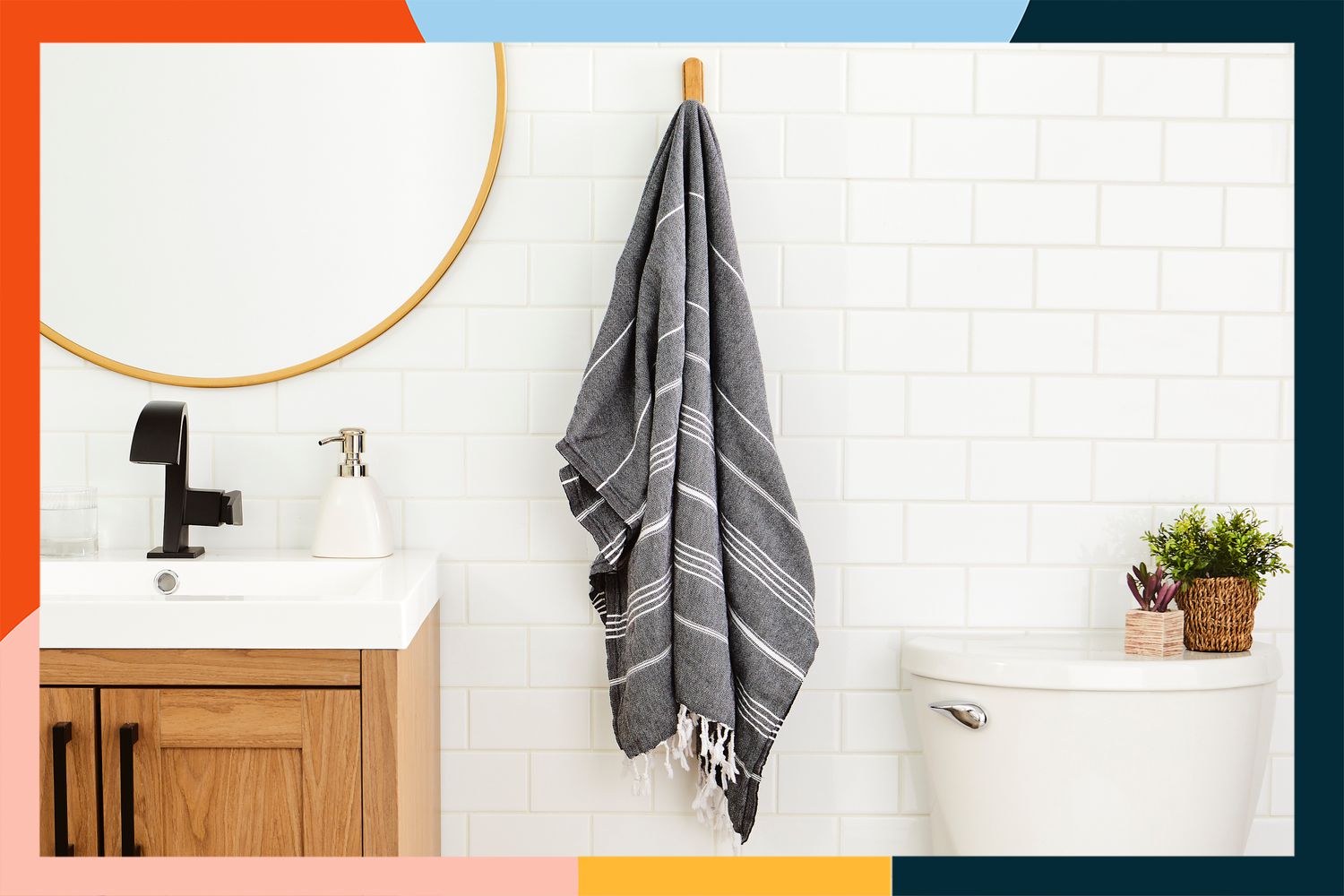 The Cacala Turkish Bath Towel handing on a bathroom wall with a colorful border