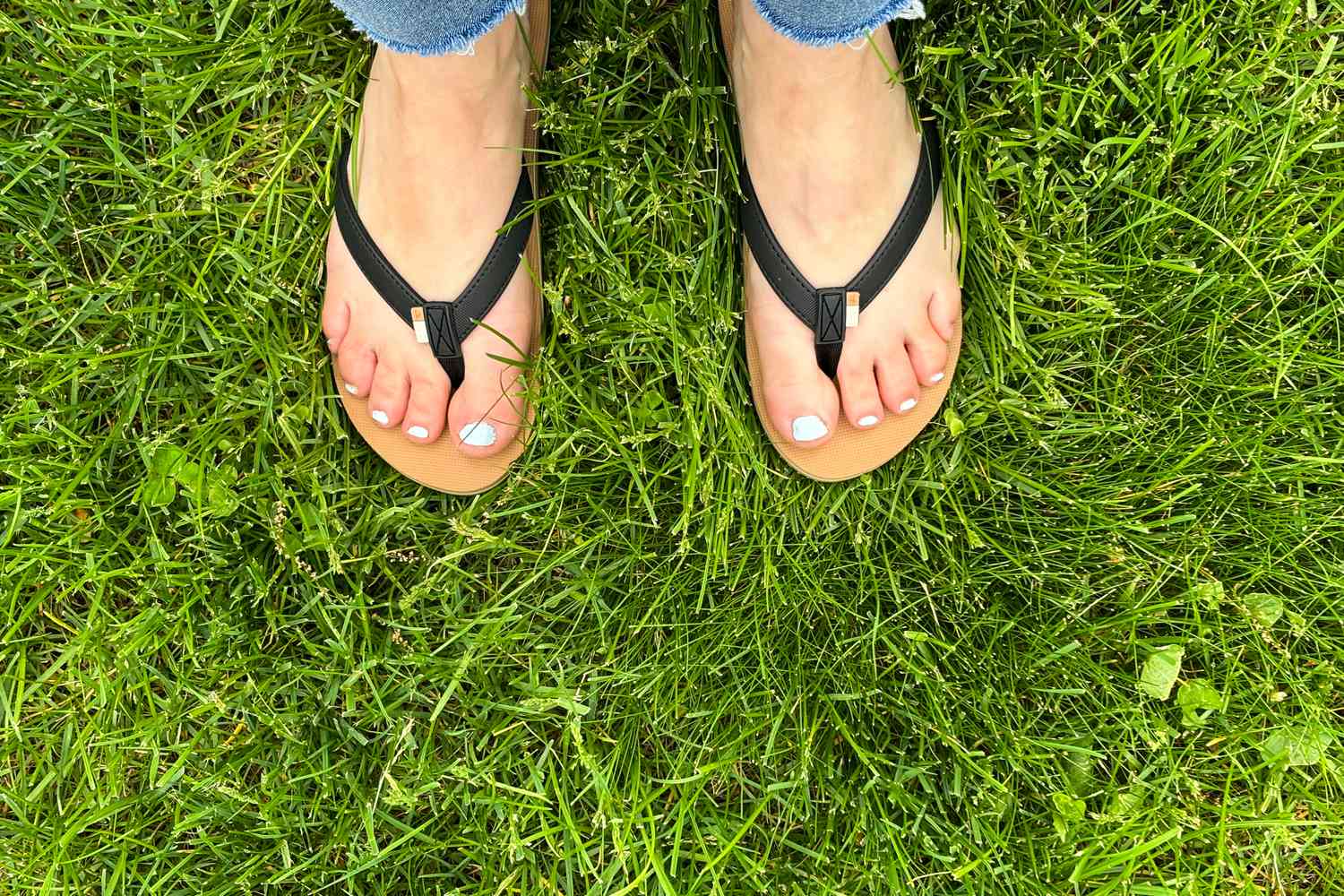 feet wearing the Reef Solana Flip Flop on grass