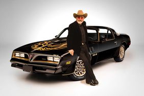 Burt-Reynolds-with-his-1977-Pontaic-Firebird-Trans-Am-Smokey-and-the-Bandit-Promo-car---sold-for-$550,000-at-the-Scottsdale-2016-Auction