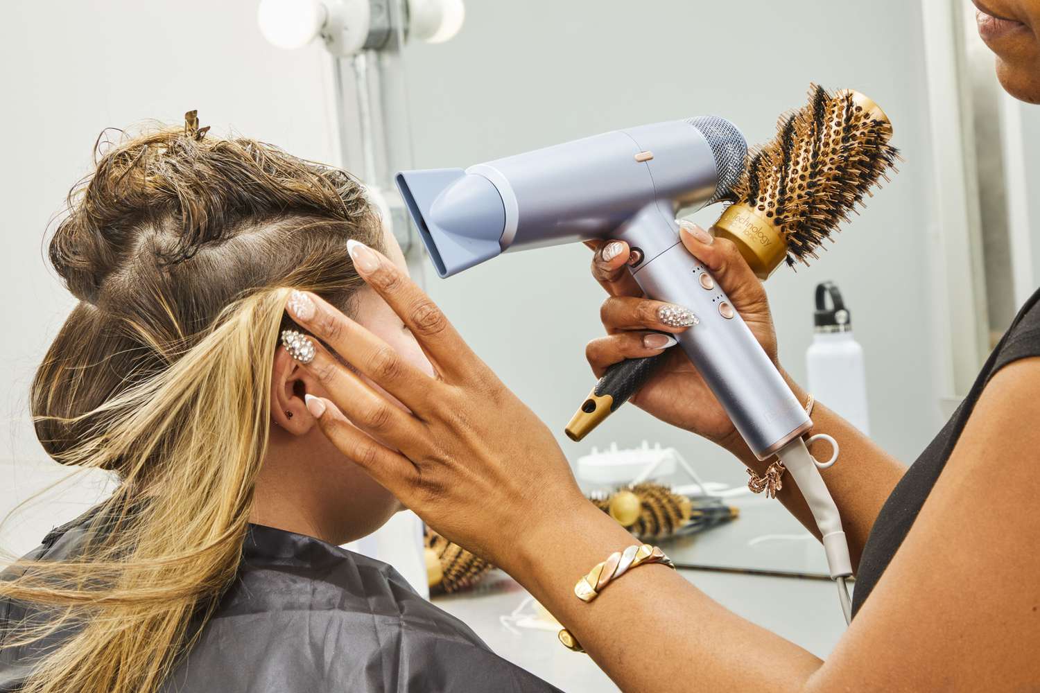 stylist uses InfinitiPRO by Conair DigitalAire Dryer to dry person's hair