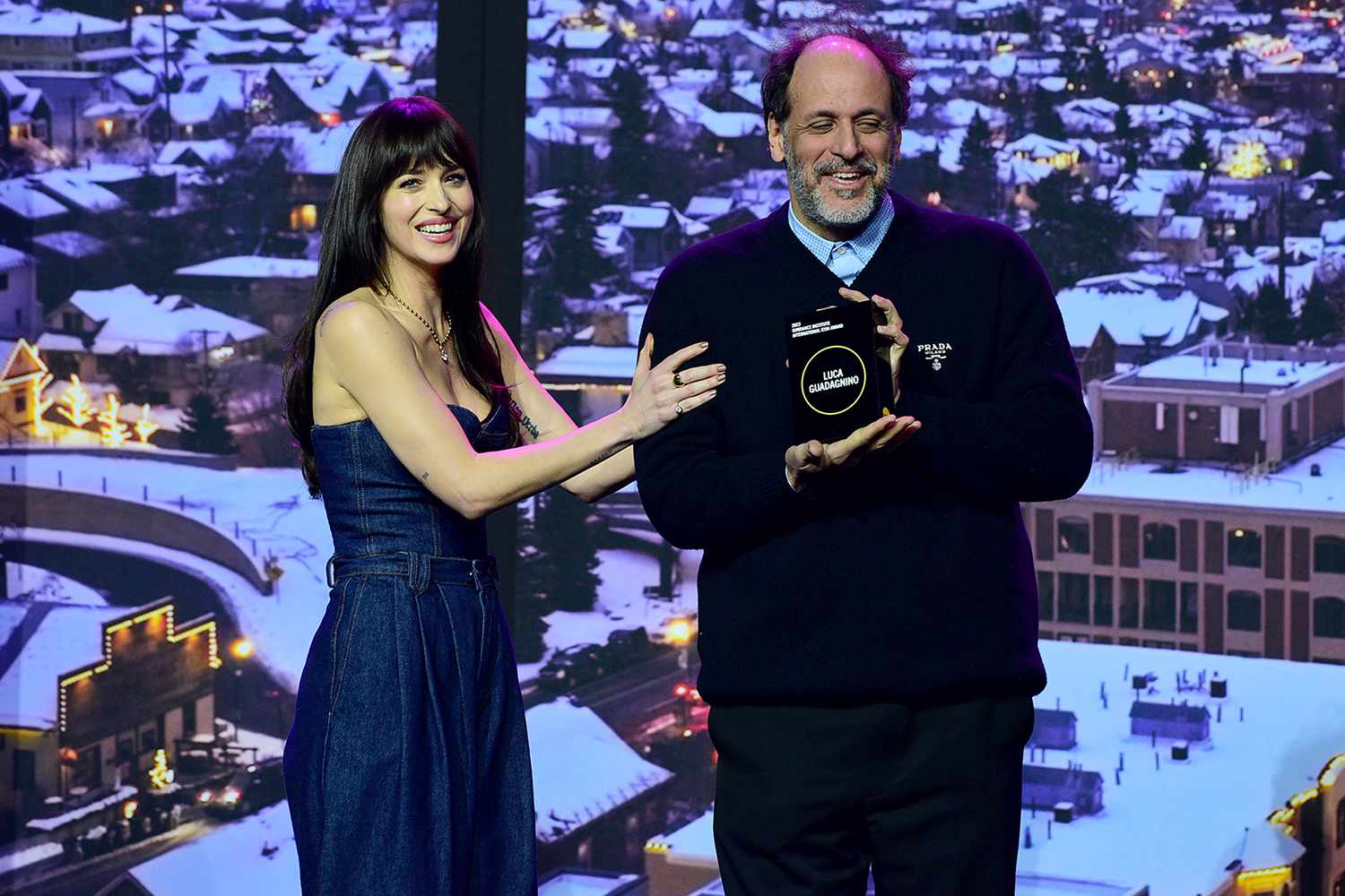 Dakota Johnson presents an award to Luca Guadagnino onstage during Sundance Institute's 'Opening Night: A Taste of Sundance Presented by IMDbPro'