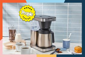 coffee maker sits on counter surrounded by cups