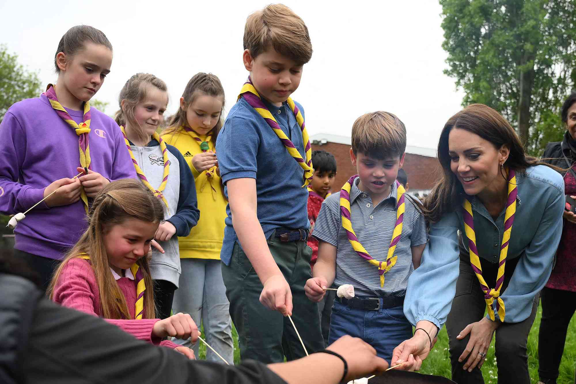 Britain's Prince William, Prince of Wales (R) looks on as (L-R) Britain's Princess Charlotte of Wales, Britain's Prince George of Wales, Britain's Prince Louis of Wales and Britain's Catherine, Princess of Wales toast marshmallows as they take part in the Big Help Out, during a visit to the 3rd Upton Scouts Hut in Slough, west of London on May 8, 2023, where the family joined volunteers helping to renovate and improve the building. - People across Britain were on Monday asked to do their duty as the celebrations for King Charles III's coronation drew to a close with a massive volunteering drive.