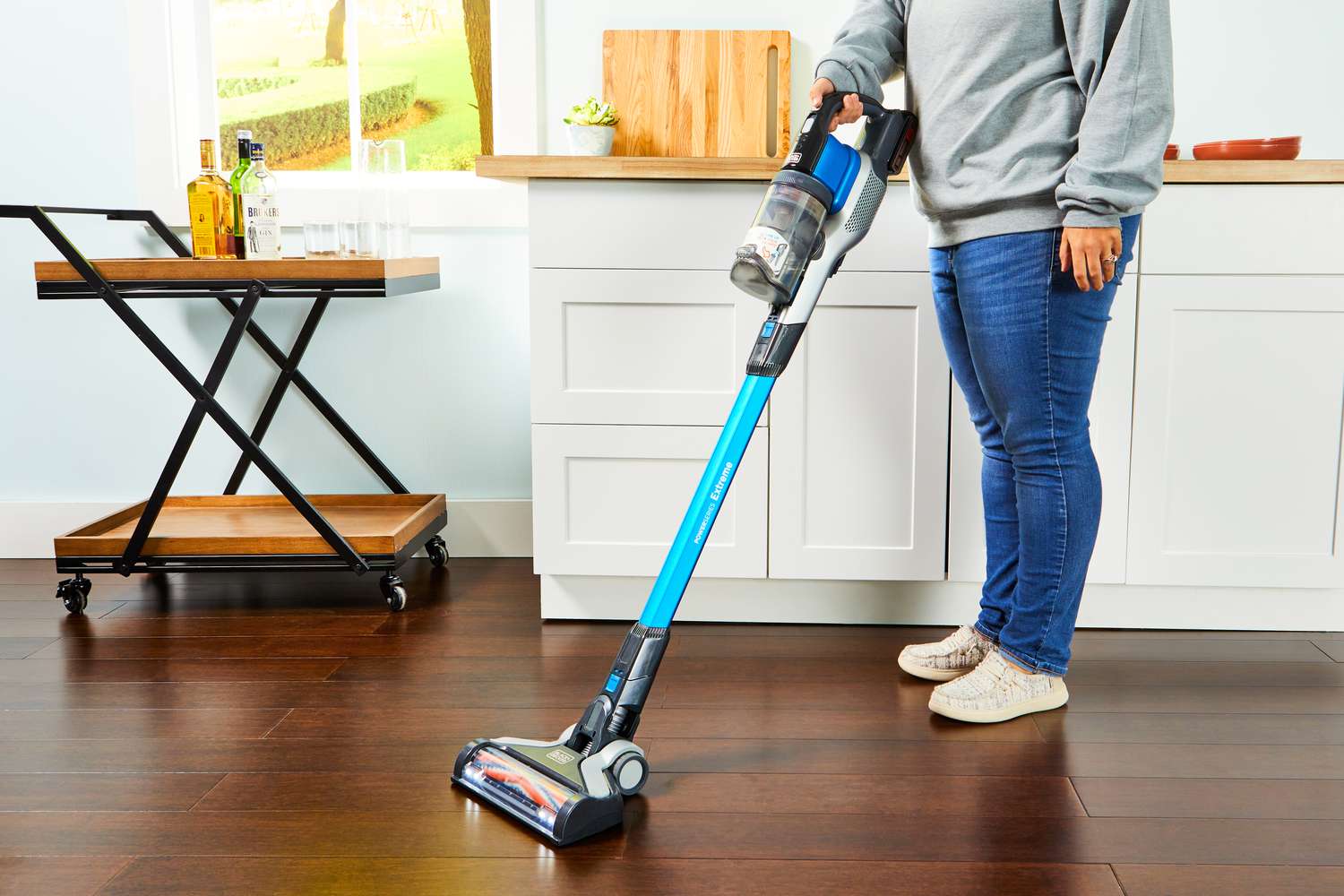 Person using the BLACK+DECKER Powerseries Extreme Cordless Stick Vacuum Cleaner to clean a hardwood floor