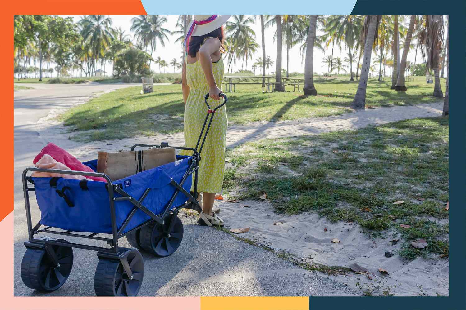 Person pulling Mac Sports Heavy Duty Collapsible Beach Wagon with nearby palm trees