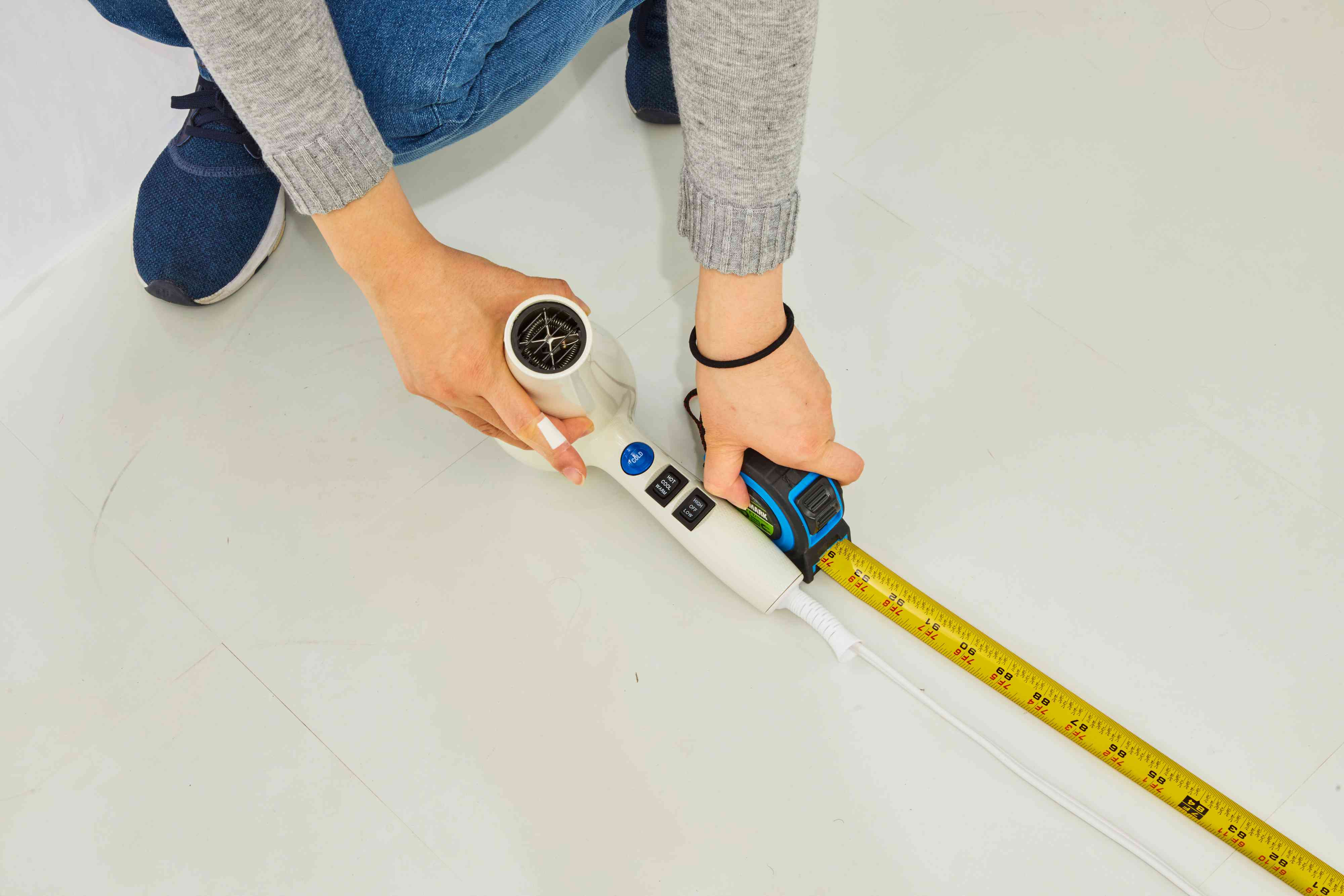 Person measuring the RuskEngineering W8less Professional 2000 Watt Dryer's power cord with a tape measure