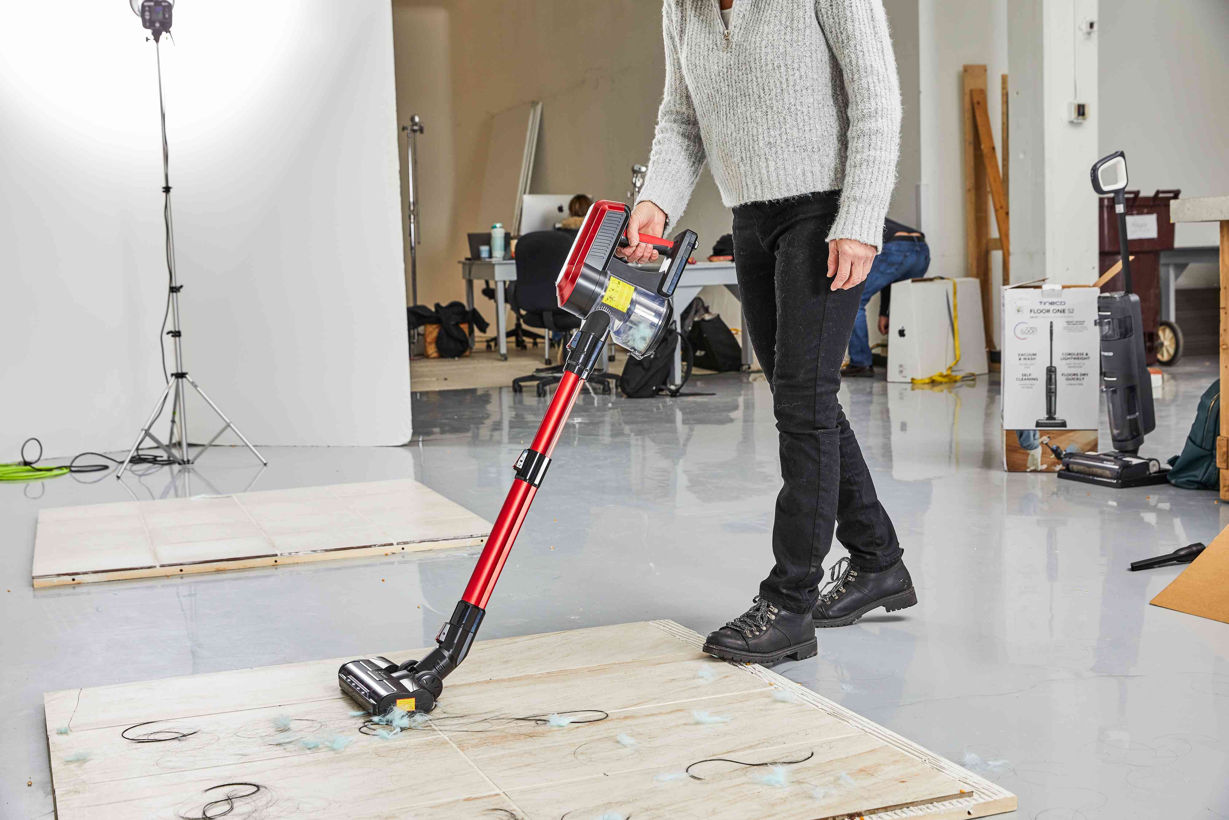 A person vacuuming with Moosoo cordless stick vacuum