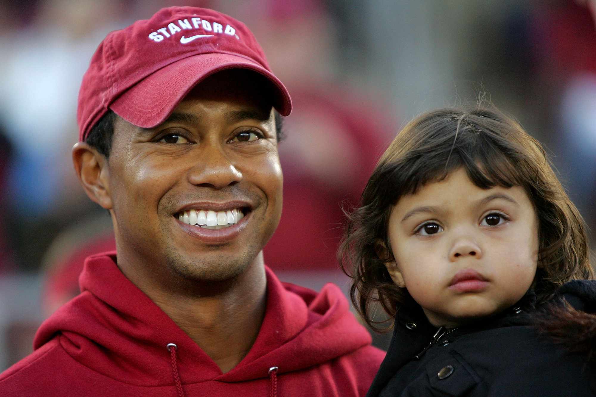 Honorary Standford Cardinal captain Tiger Woods holds his daugher, Sam, on the sidelines before the Cardinal game against the California Bears at Stanford Stadium on November 21, 2009 in Palo Alto, California. 