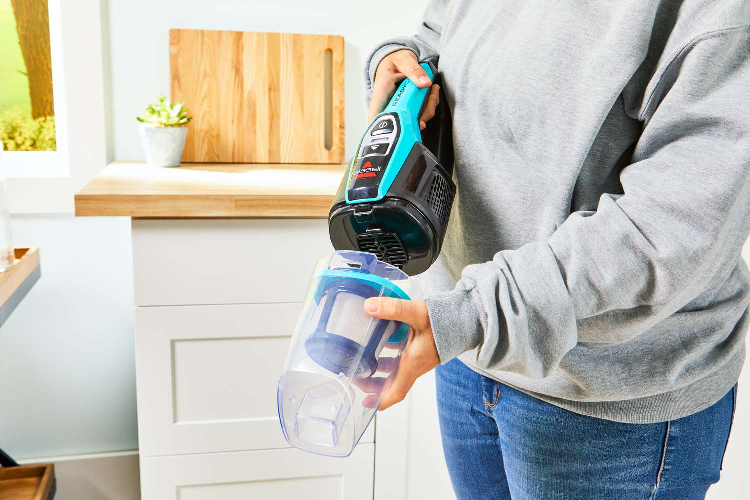A person removes the handheld attachment of the BISSELL 3061 Featherweight Cordless Stick Vacuum.