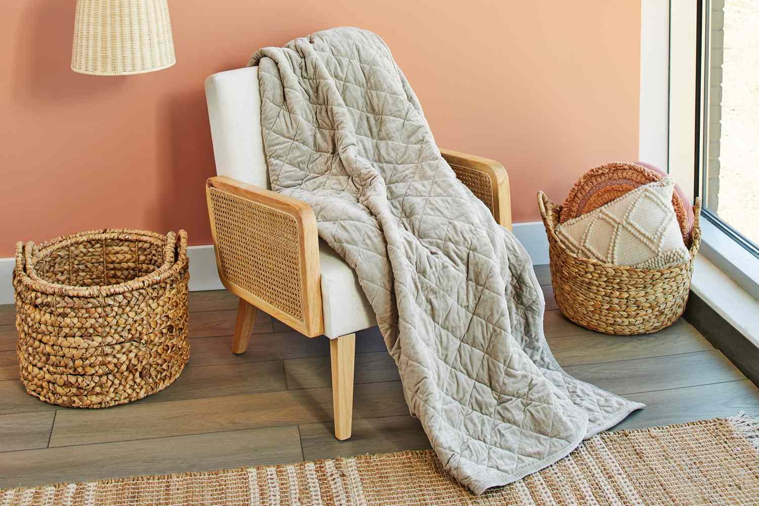 Saatva Organic Weighted Blanket on white chair with laundry basket