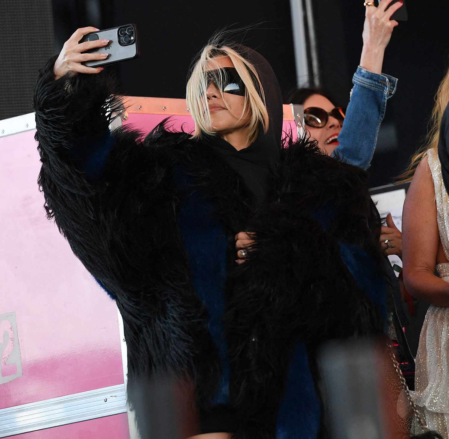 Kourtney Kardashian stands on the side of the stage as her husband Travis Barker performs with his band Blink-182 during the first week-end of Coachella Valley