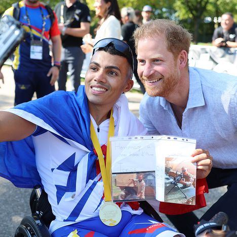 Prince Harry, Duke of Sussex takes a selfie with a winner at the cycling medal ceremony and and hands over a medal to the winning team at the Cycling Track during day six of the Invictus Games 