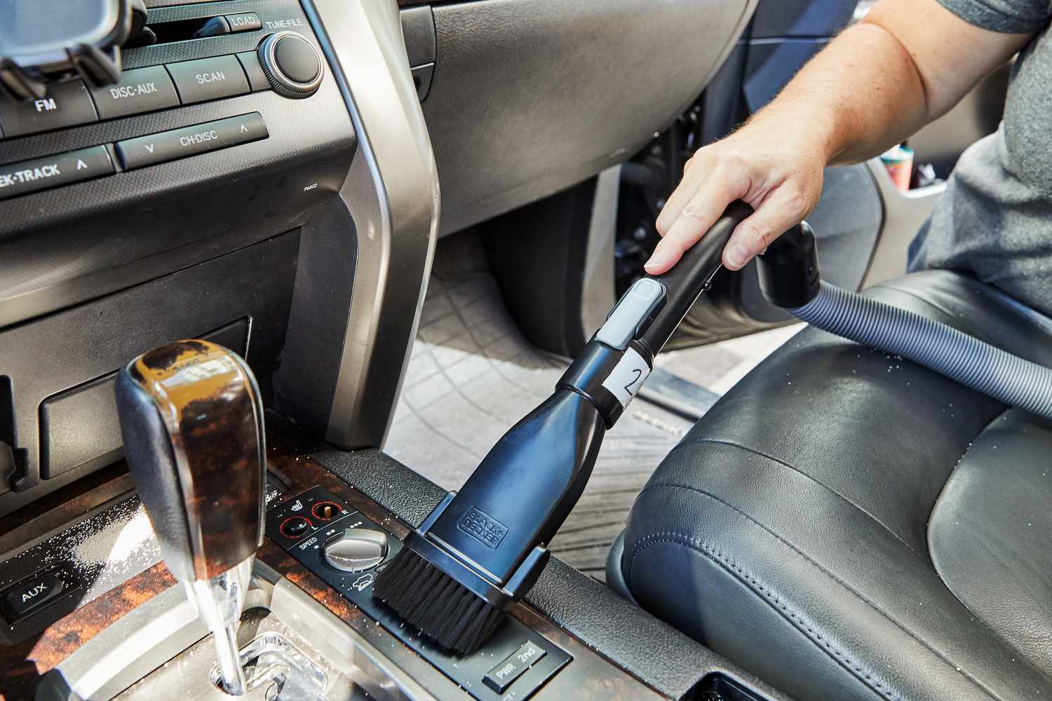 Person using the Black+Decker Flex Cordless Handheld Vacuum to clean inside car