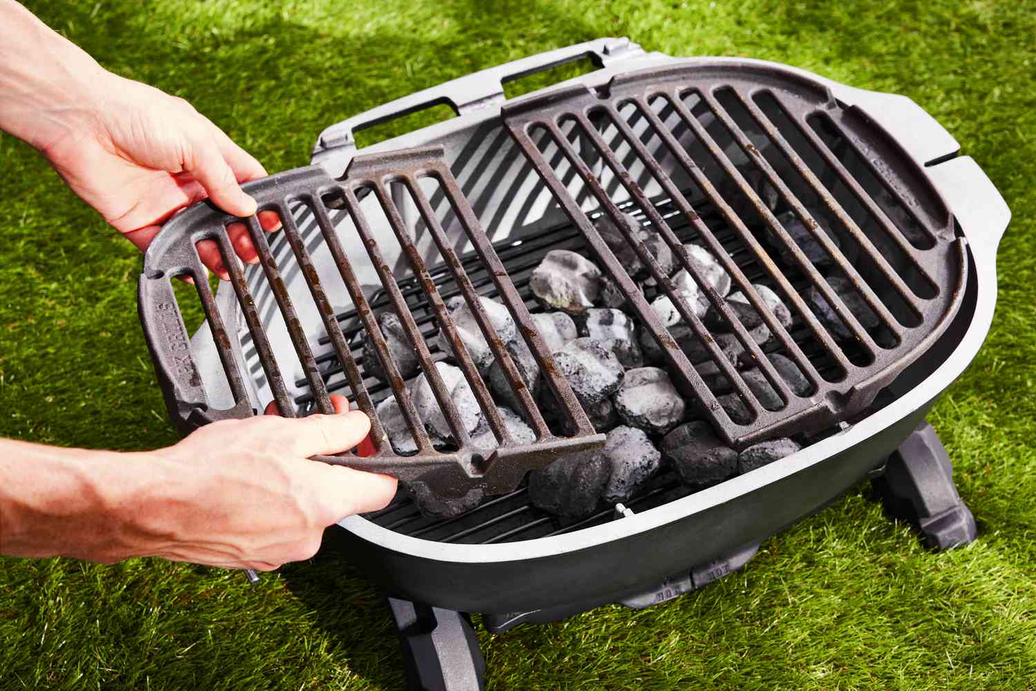 Person removing the charcoal pieces from PK Grills PKGo Camp & Tailgate Grilling System