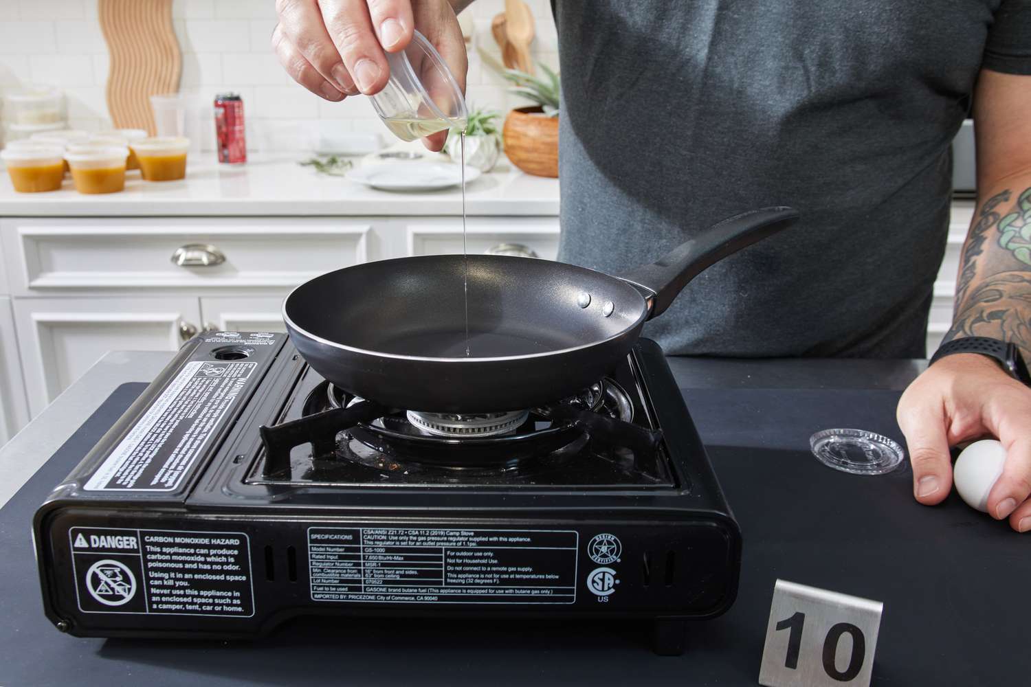 A person pours oil in the Farberware Dishwasher Safe Nonstick 15 Piece Cookware Pots and Pans Set pan