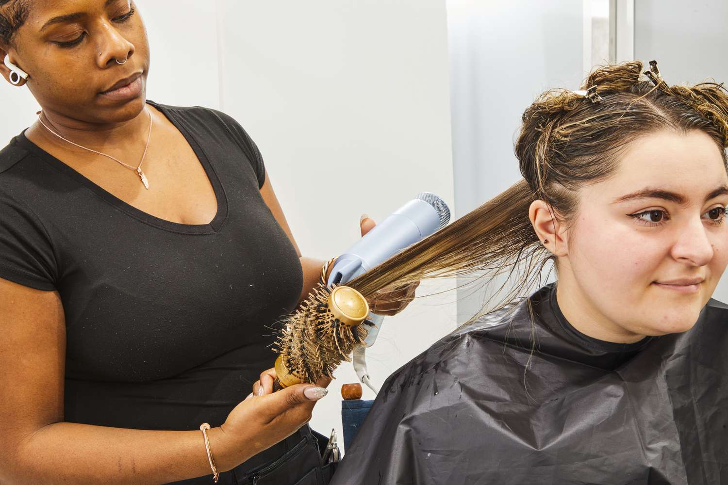 stylist uses brush and InfinitiPRO by Conair DigitalAire Dryer to dry person's hair