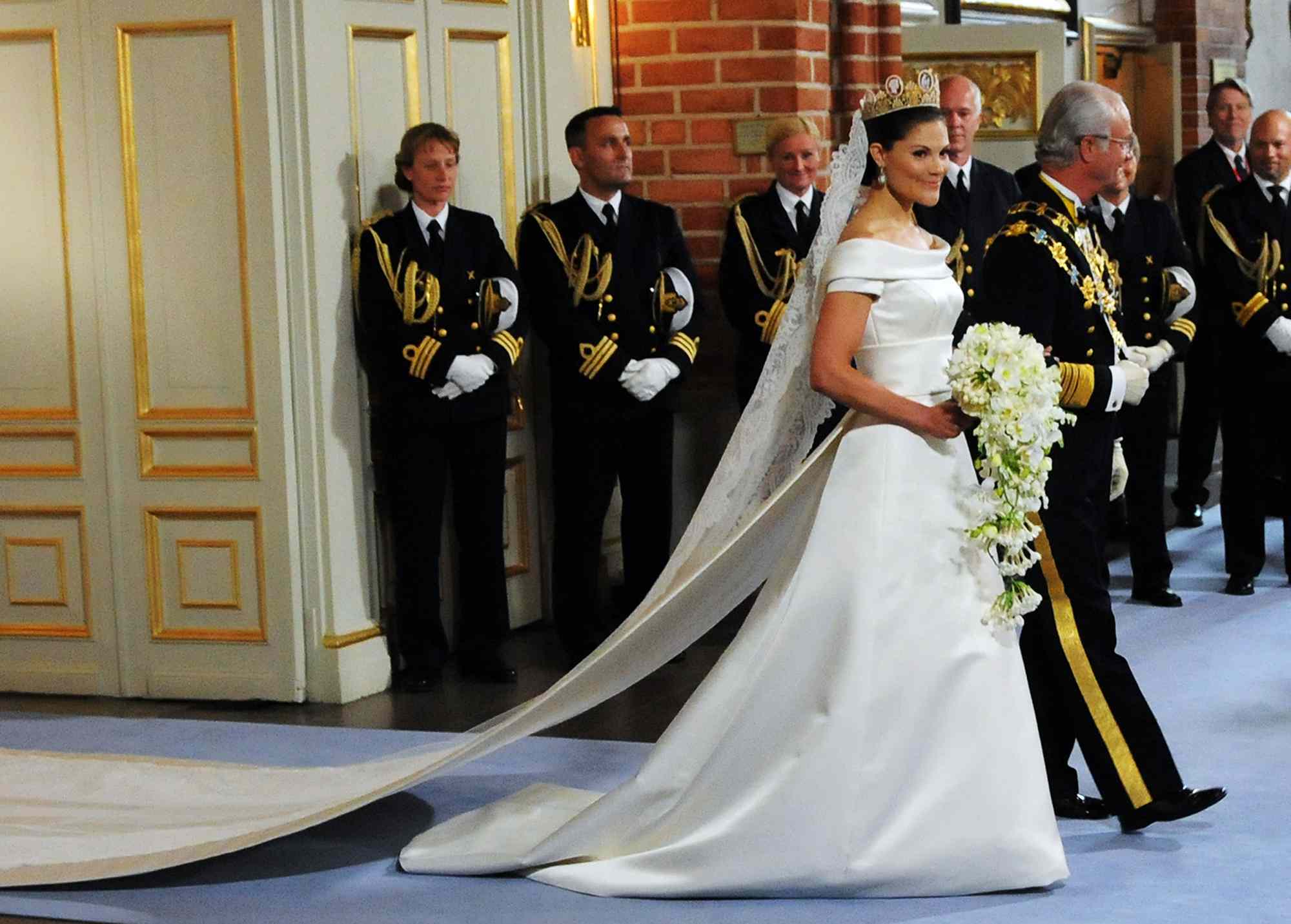 Crown Princess Victoria of Sweden is led into the church by her father the king Carl Gustaf of Sweden