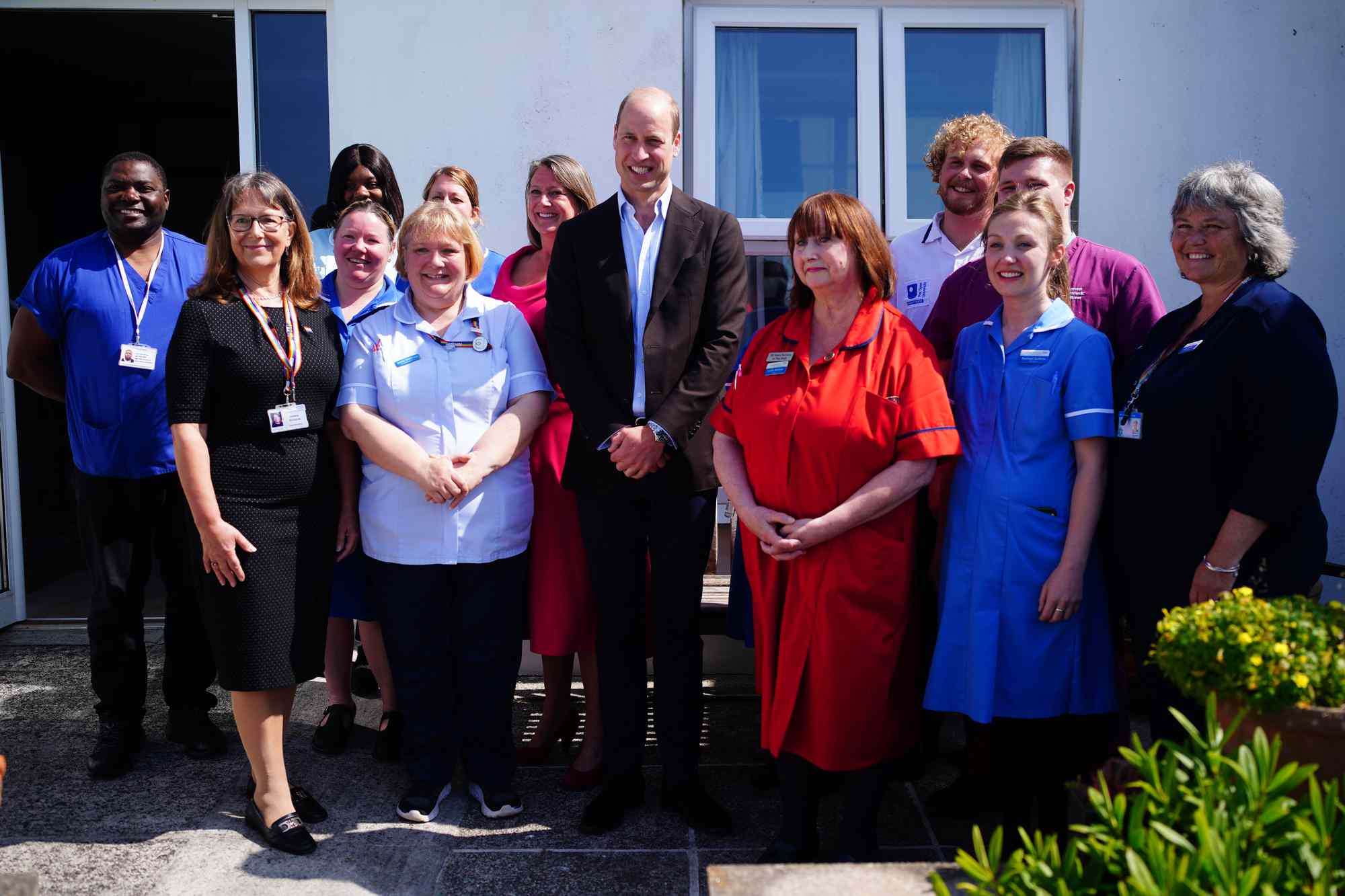 Prince William, Prince of Wales, known as the Duke of Cornwall when in Cornwall, poses next to Lynda McHale (in red) and other staff members during a visit to St. Mary's Community Hospital, Isles of Scilly, to meet staff and hear about a new integrated health and social care facility which is set to be built on adjacent land owned by the Duchy of Cornwall on May 10, 2024 in Isles of Scilly, England.